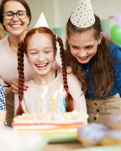 Group of happy children looking at cake during fun Birthday party, copy space